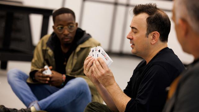 illusionist demonstrates a card trick to students